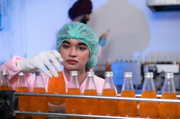 Foto personale di controllo della qualità del prodotto alla linea di produzione di succhi di frutta eseguire controlli della qualità dei prodotti