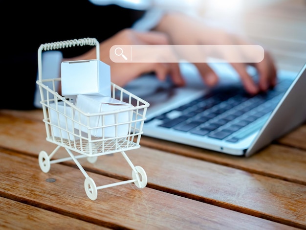 Product search on online shopping store application on internet with laptop computer shopping online concepts Searching engine tab virtual on the shopping cart trolley with parcel boxes on desk