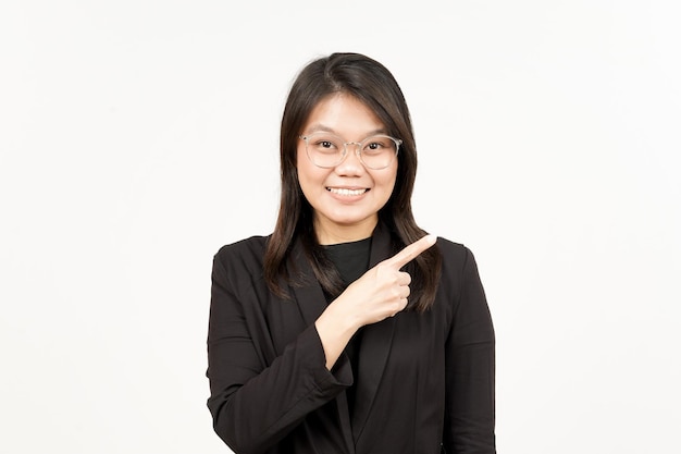 Product tonen en wijzende kant van mooie Aziatische vrouw, gekleed in zwarte blazer geïsoleerd op wit