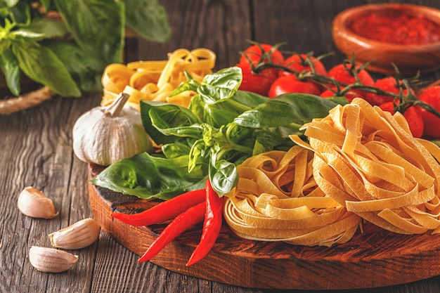 Producten om te koken - pasta, tomaten, knoflook, peper en basilicum