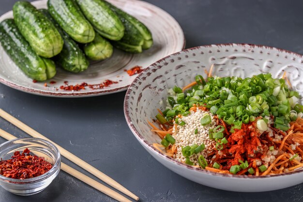 Producten voorbereiden voor het koken van traditionele Koreaanse komkommerkimchi-snack: het mengen van ingrediënten in een kom, gefermenteerd voedsel, horizontale foto