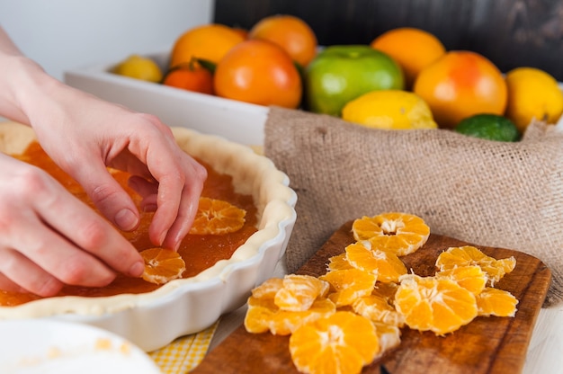 Productie van cake met citrusmarmelade en schijfjes mandarijn