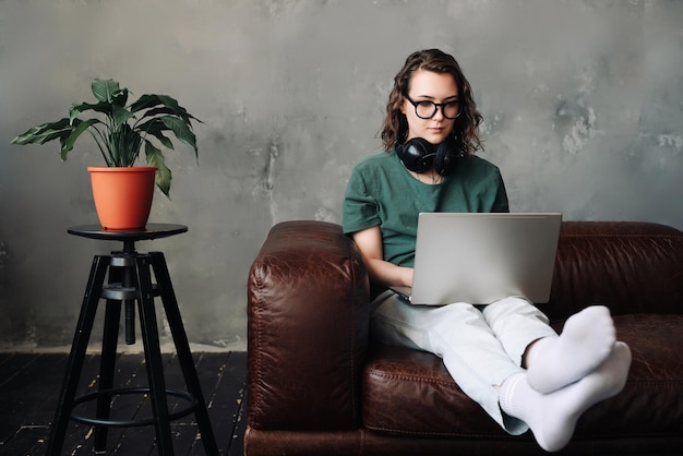 Productieve thuiskantoor jonge vrouw die zich bezighoudt met laptopwerk dat werk van thuis uit freelancen vertegenwoordigt