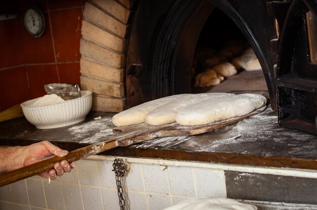 Production of baked bread with a wood oven in a bakery.