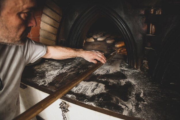 Production of baked bread with a wood oven in a bakery.