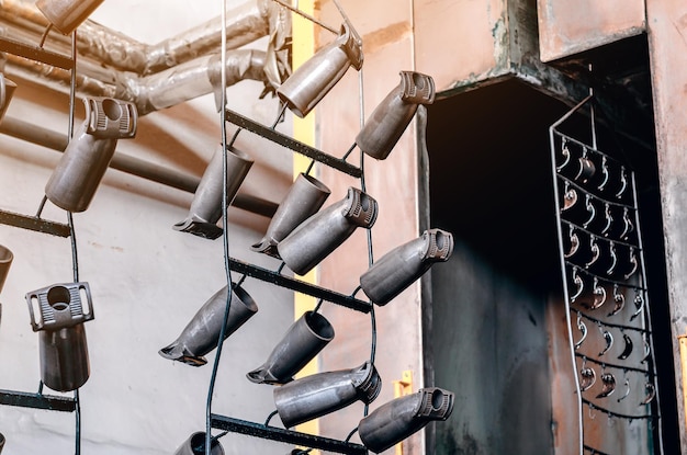 Production details hung on metal hangers in workshop Strong rough industrial tools