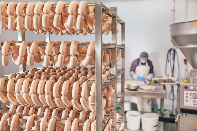 production of sausages from veal chicken and pork meat the worker holds sausages in his hands and