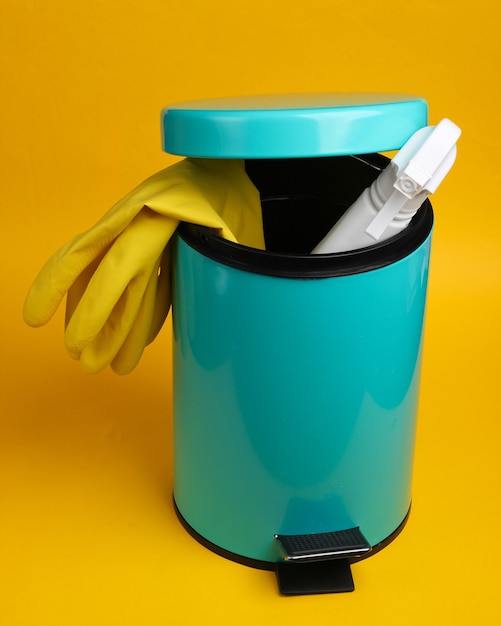 Products for cleaning in the bin on a yellow background