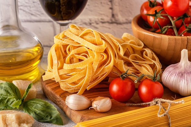 Products for cooking pasta, tomatoes, garlic, olive oil, basil