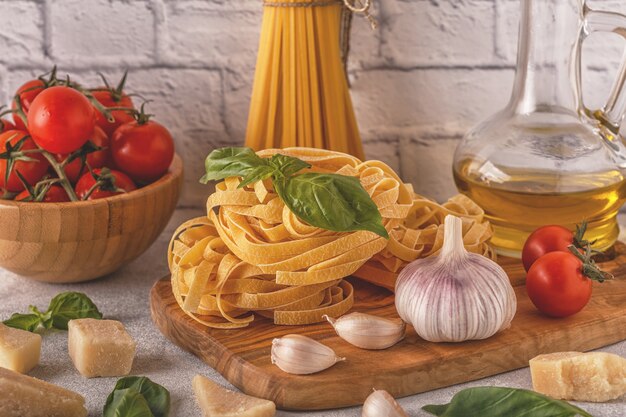 Products for cooking pasta, tomatoes, garlic, olive oil, basil