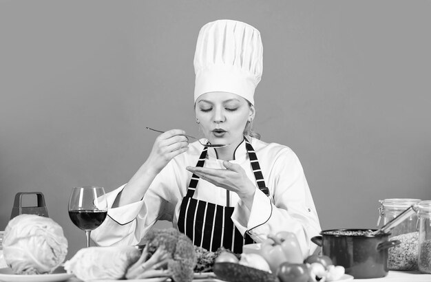 Foto proef de smaak klaar om nieuwe schotel te koken verse vegetarische salade chef-kok in commerciële keuken professionele chef-kok met gezonde producten gelukkige glimlachende chef-kok die maaltijd met diverse groenten voorbereidt