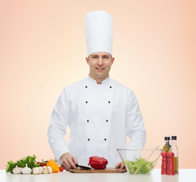 profession, vegetarian, food and people concept - happy male chef cooking vegetable salad over beige background