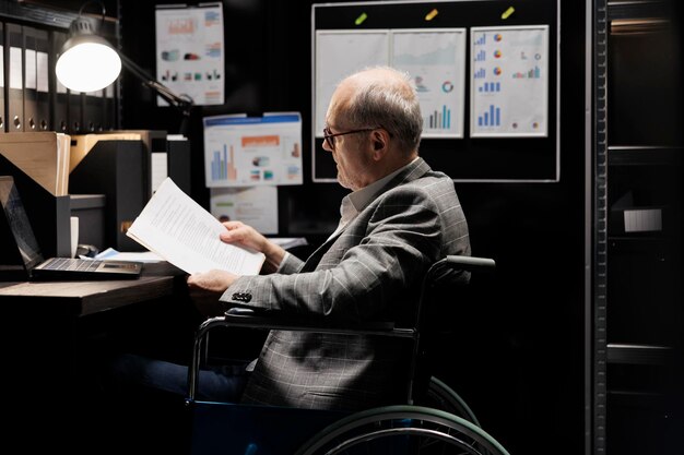 Photo professional accountant in wheelchair checking administrative paperwork in dark file room. businessman in bureaucratic file cabinet office filled with invoice folders and flowcharts