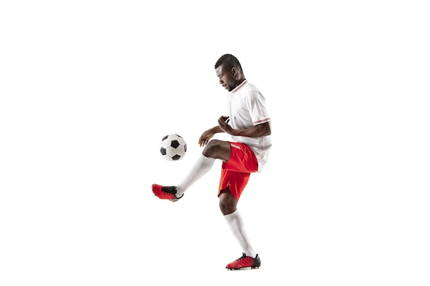 Photo professional african american football soccer player in motion isolated on white studio background. fit jumping man in action, jump, movement at game.