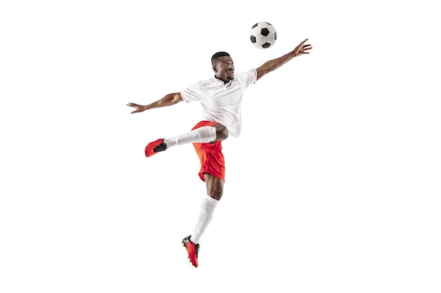 Professional african american football soccer player in motion isolated on white studio background. Fit jumping man in action, jump, movement at game.