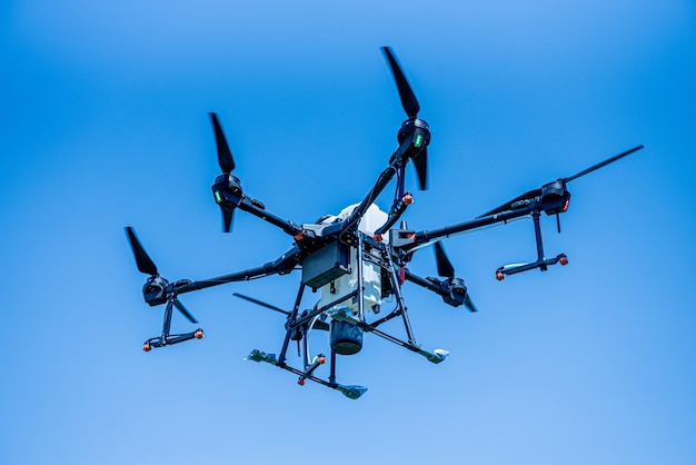 Professional agriculture drone flying in the blue sky