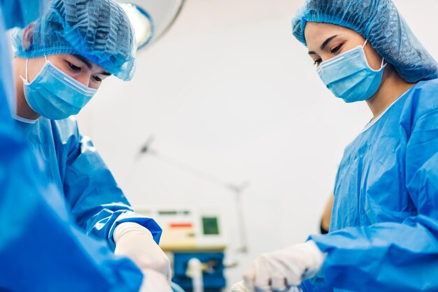 Professional anesthesiologist doctor medical team and assistant preparing patient to gynecological surgery performing operating with surgery equipment in modern hospital operation emergency room