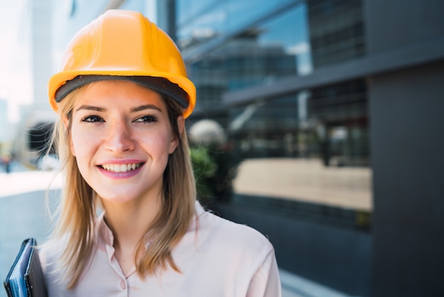 屋外に立っているプロの建築家の女性。