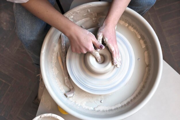 Professional artisan makes a bowl with a fast spinning potters wheel creating ceramics top view