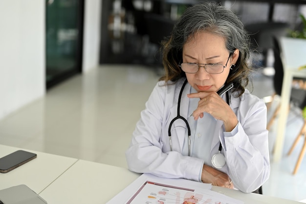 Professional Asian aged female doctor concentrating on her medical research