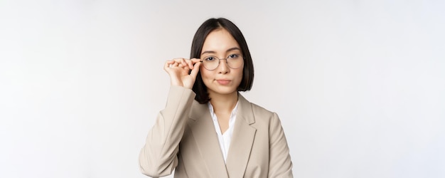 Professional asian businesswoman in glasses looking confident at camera standing in power pose again