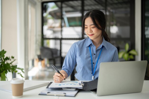 Photo a professional asian businesswoman is signing documents and working on her business work