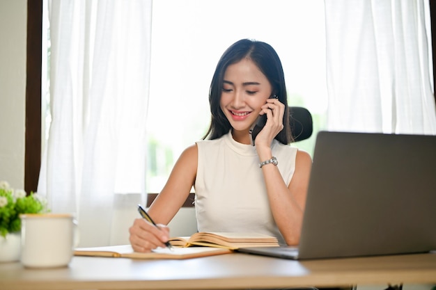 Professional Asian businesswoman talking on the phone while working in the office