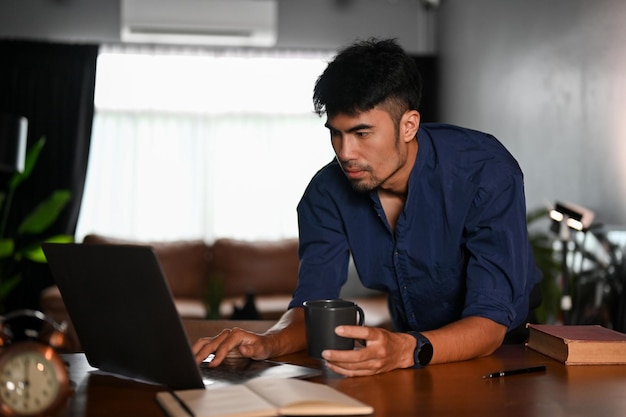 Профессиональный азиатский офисный работник или инженер-мужчина, использующий портативный ноутбук