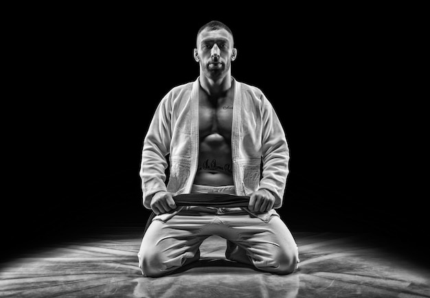 Photo professional athlete sits in the gym. concept of karate, jiu-jitsu, sambo, judo. mixed media