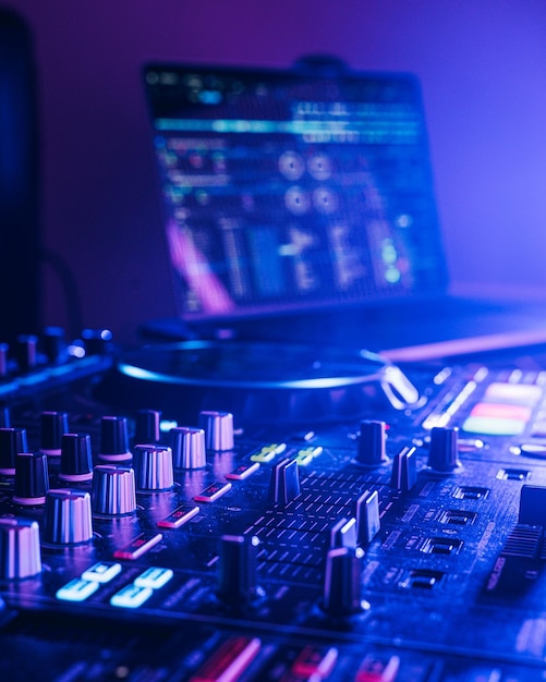 Professional audio mixing board connected to a laptop displaying the various knobs and buttons