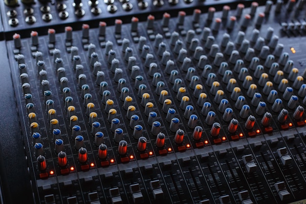 Foto pannello della console del mixer audio professionale da studio audio con fader di registrazione e manopole di regolazione