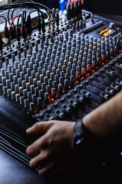 Professional audio studio sound mixer console board panel with\
recording faders and adjusting knobs