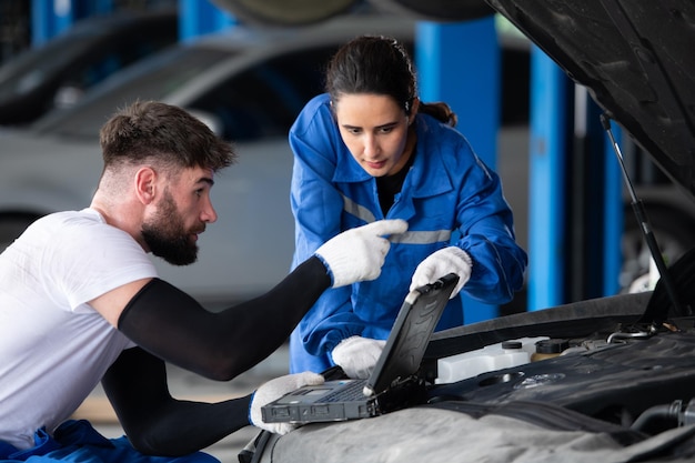 Professional auto mechanic man and woman working together in auto repair shop