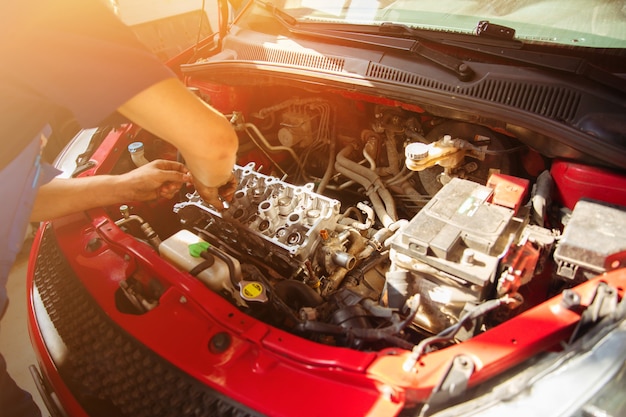 Professional auto repairman fixes a car at a service station and uses special tools