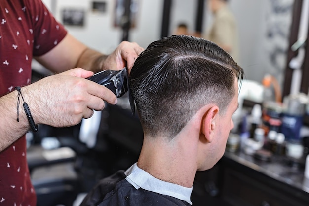 Professional barber styling hair of his client