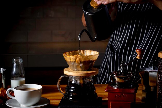 Photo professional barista preparing coffee using chemex pour over coffee maker and drip kettle