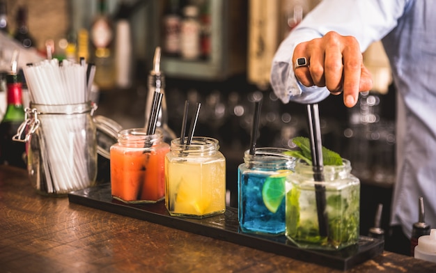 Professional barman preparing cocktails at fashion bar