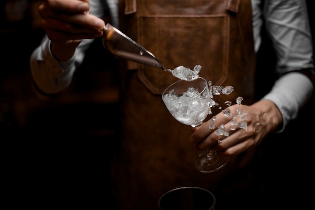 Photo professional bartender putting crushed ice to the glass