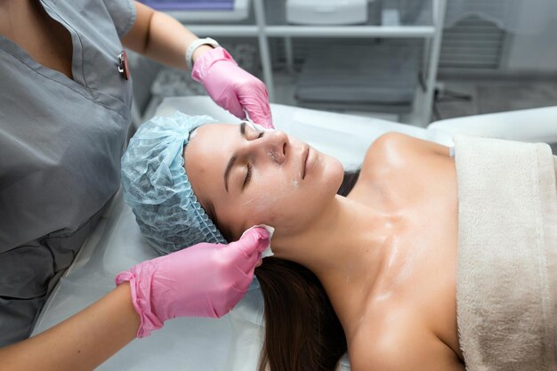 Foto un'estetista professionista esegue una procedura meccanica di pulizia del viso presso la spa bella donna caucasica in un centro sanitario di procedura cosmetica