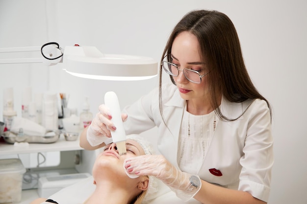 A professional beautician performs a mechanical facial cleansing procedure