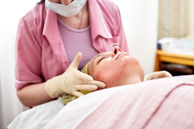 Professional  beautician puts on skin for the chemical peel