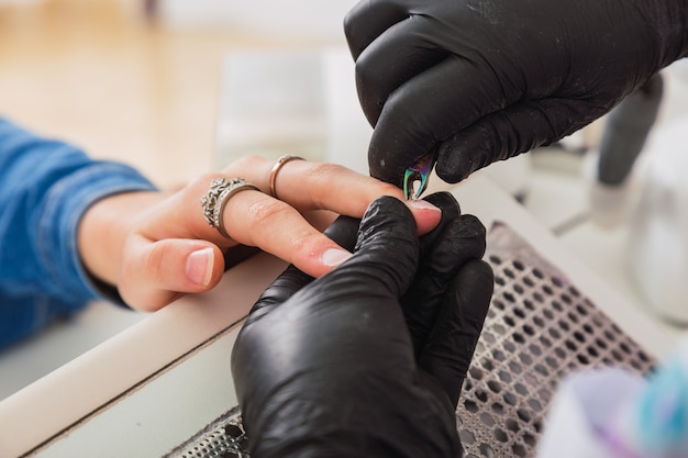 Professional beautician trims client's cuticles