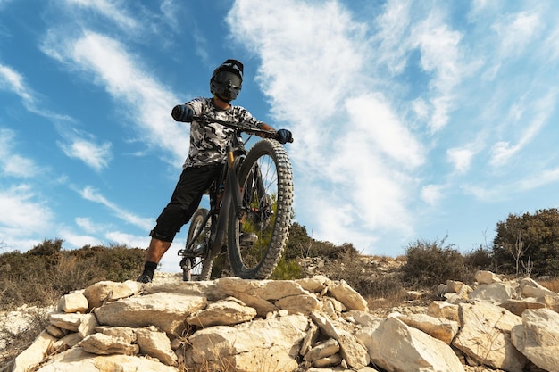 写真 山で彼の自転車にダウンヒルライド中のプロの自転車ライダー