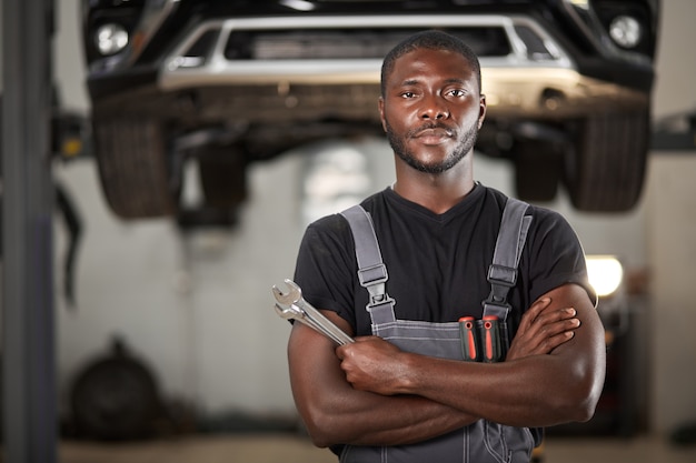 Professional black auto mechanic looking at camera