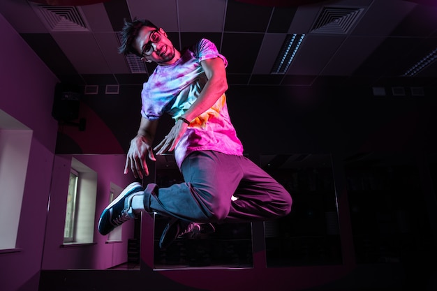 핑크 네온 불빛에서 현대 힙합 댄스를 연습하는 전문 브레이크 댄서