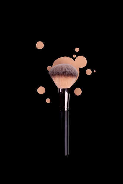 Professional brush with black handle for make up with drops of beige foundation bb cream