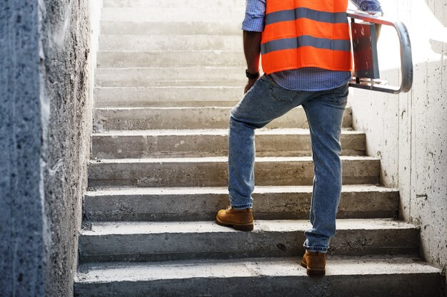 Foto costruttore professionista che trasporta la scala di metallo da vicino