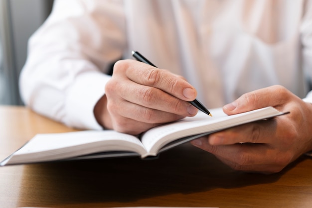 Scrittura professionale dell'uomo di affari in taccuino