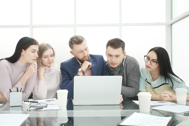 Professional business team looks closely at the laptop screen