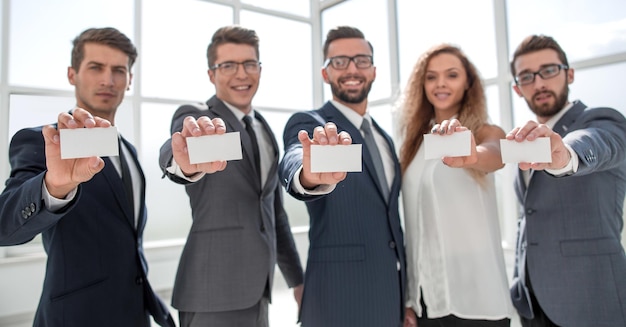 Foto squadra professionale di affari che mostra i loro biglietti da visitaconcetto di partnership